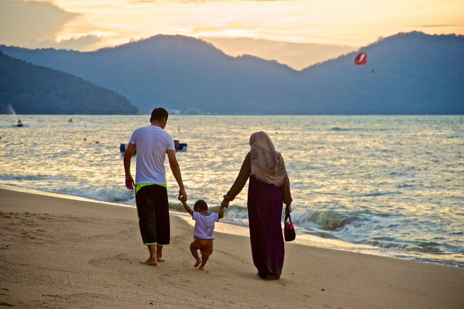 Photo by Patrick Boucher man and woman holding hands while walking on beach during daytime