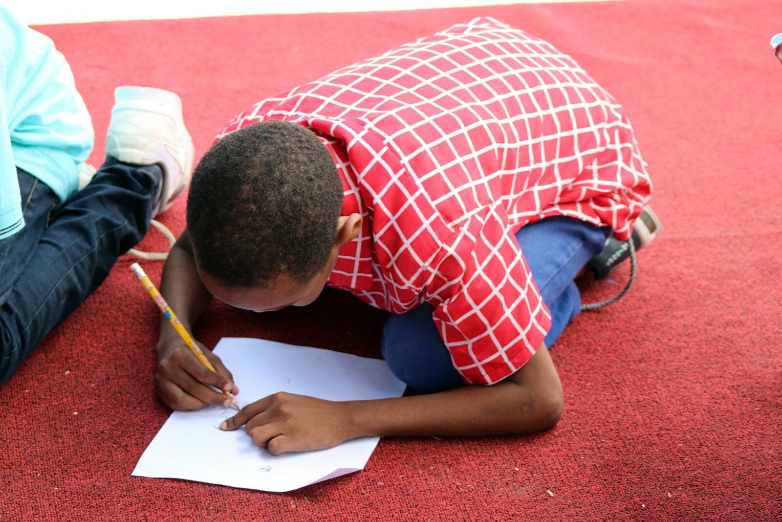 Photo by Ismail Salad Osman Hajji dirir man in red and white plaid button up shirt writing on white paper