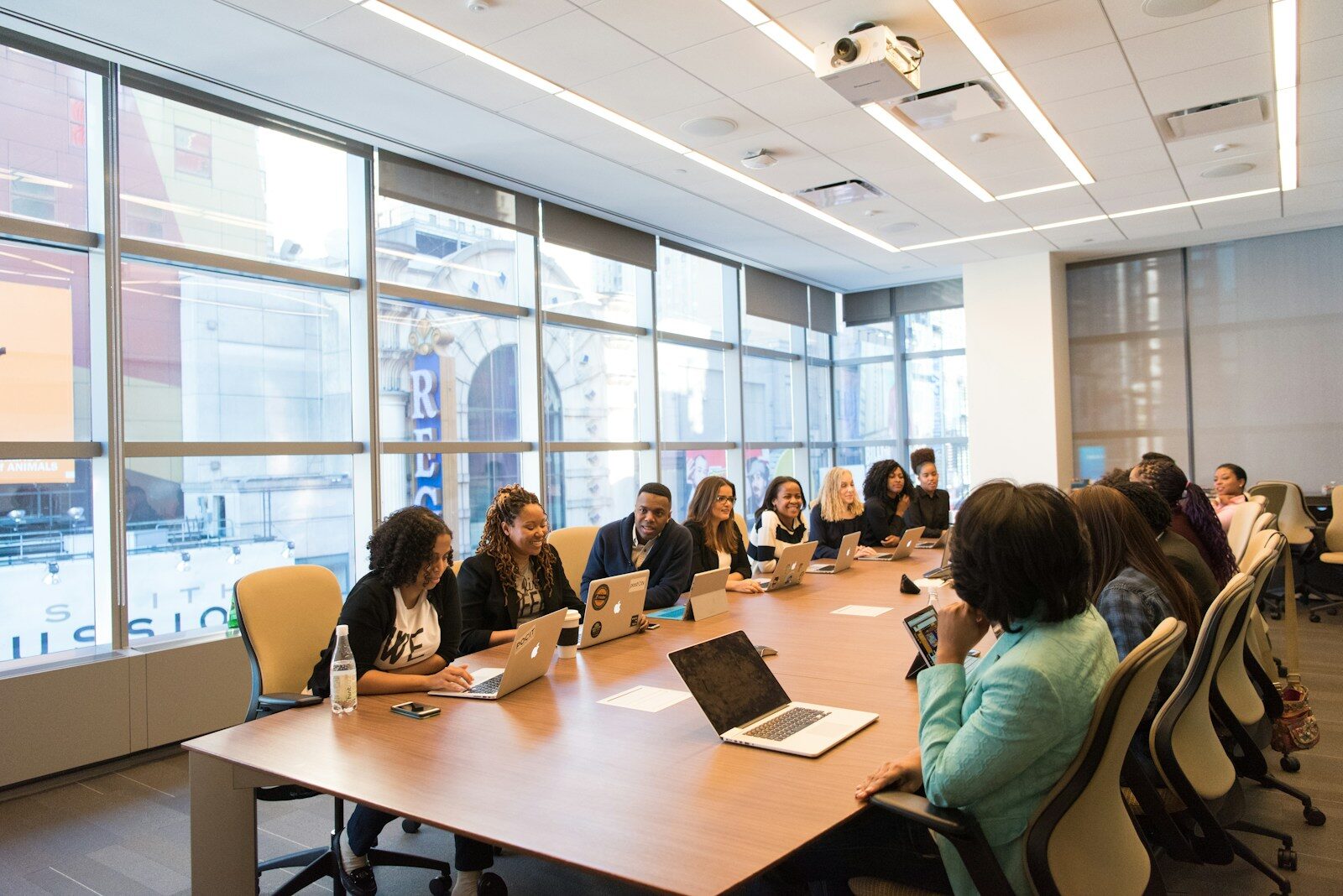 Photo by Christina @ wocintechchat.com M group of people sitting beside rectangular wooden table with laptops